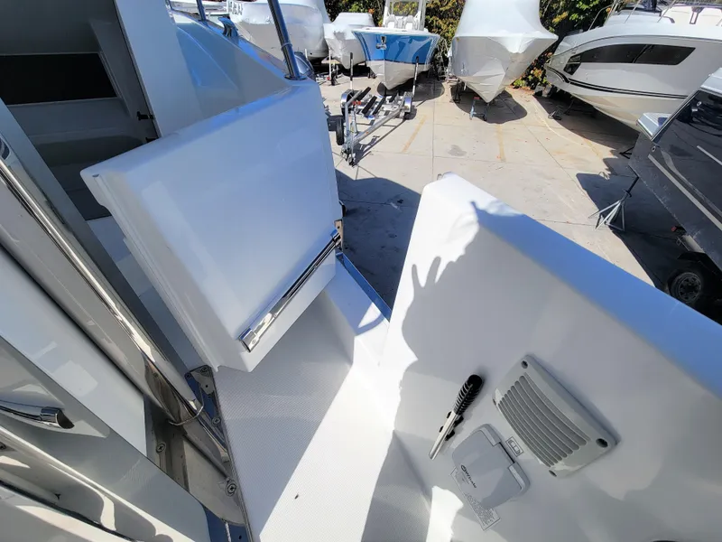 Slide: The Image of 2024 Jeanneau Leader 12.5 WA boat deck with open hatch and docked boats. - 26