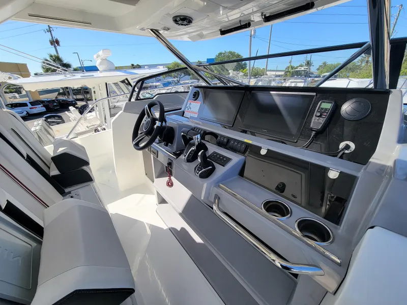 Slide: The Image of 2024 Jeanneau Leader 12.5 WA helm station with modern controls and navigation screens. - 27