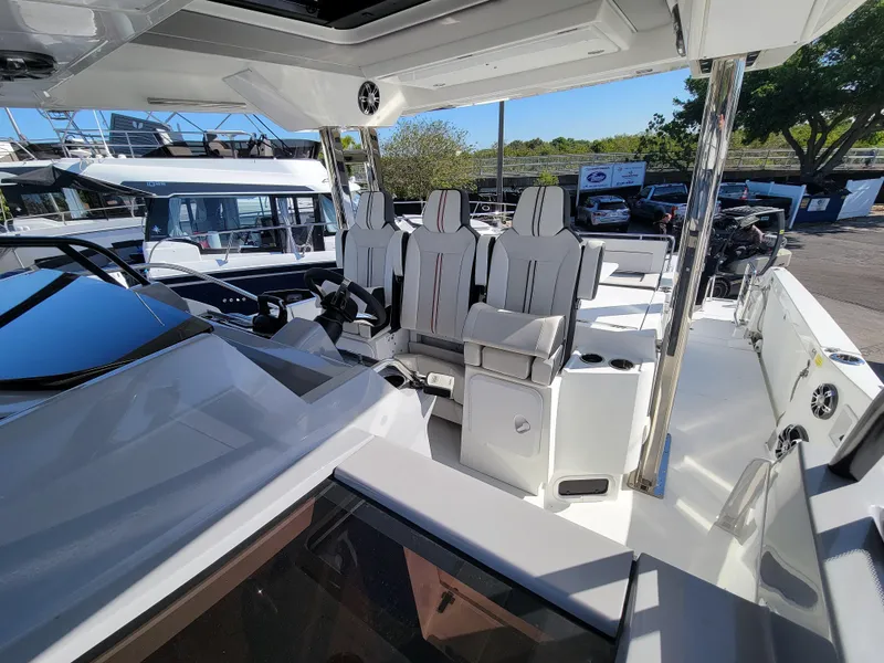 Slide: The Image of 2024 Jeanneau Leader 12.5 WA boat interior with modern seating and helm station. - 38