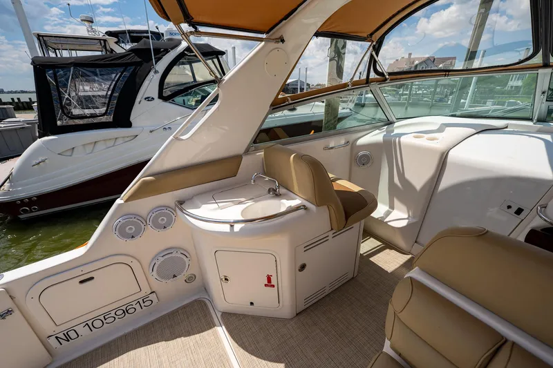 Slide: The Image of 1997 Sea Ray 330 Sundancer interior with seating and helm, docked at marina. - 14