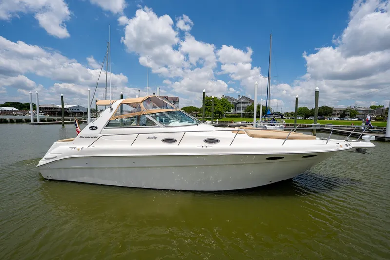 Slide: The Image of 1997 Sea Ray 330 Sundancer yacht on calm water under a blue sky. - 2