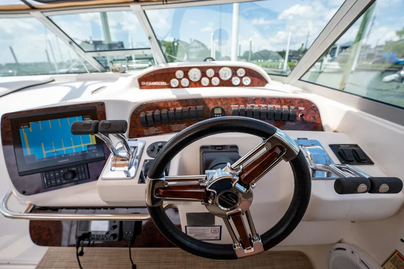 Slide: The Image of 1997 Sea Ray 330 Sundancer helm with steering wheel, gauges, and navigation equipment. - 21