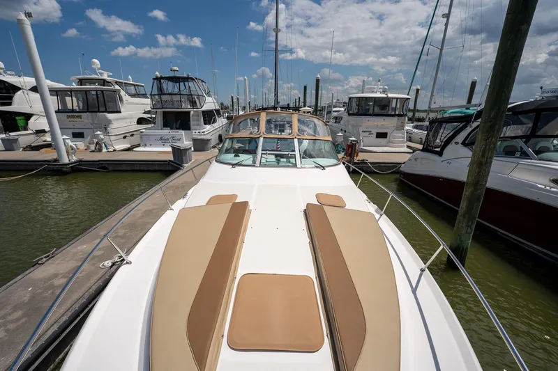 Slide: The Image of 1997 Sea Ray 330 Sundancer docked at marina, surrounded by other boats under a blue sky. - 23