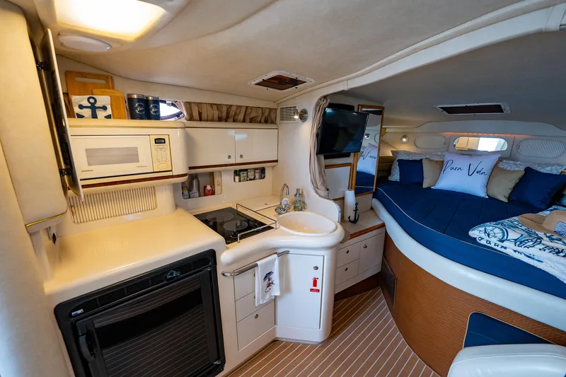 Slide: The Image of Interior of 1997 Sea Ray 330 Sundancer yacht with kitchenette and cozy sleeping area. - 25