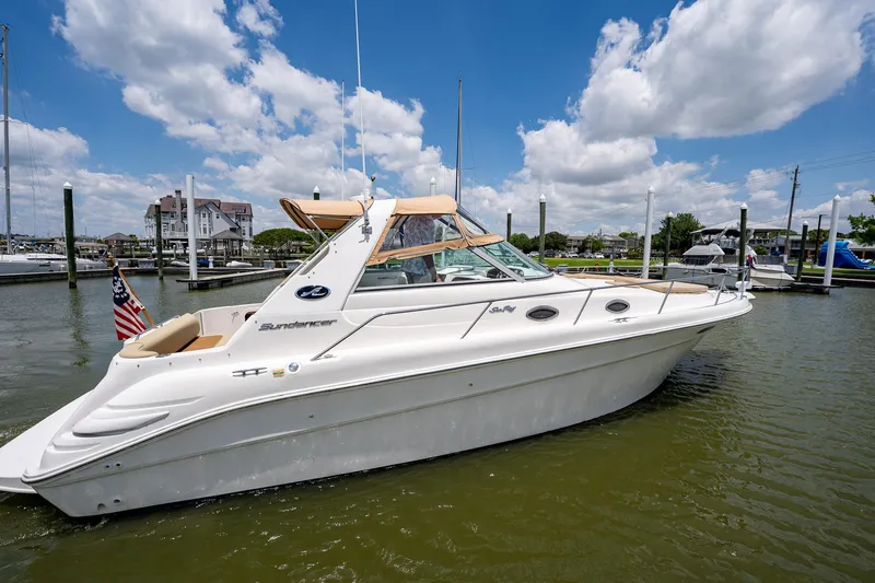 Slide: The Image of 1997 Sea Ray 330 Sundancer boat docked in a marina under a blue sky. - 3