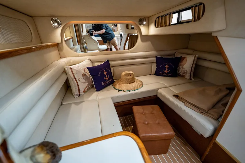 Slide: The Image of 1997 Sea Ray 330 Sundancer cabin with cozy seating, nautical decor, and a straw hat. - 37