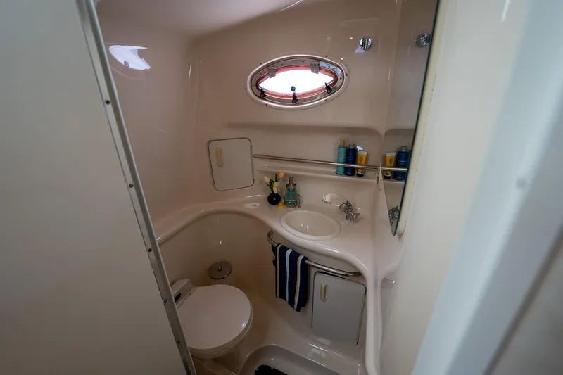 Slide: The Image of Bathroom interior of 1997 Sea Ray 330 Sundancer yacht, featuring sink and porthole window. - 38