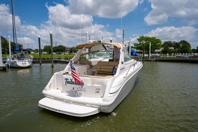 Slide: The Image of 1997 Sea Ray 330 Sundancer boat docked in a marina under a partly cloudy sky. - 4
