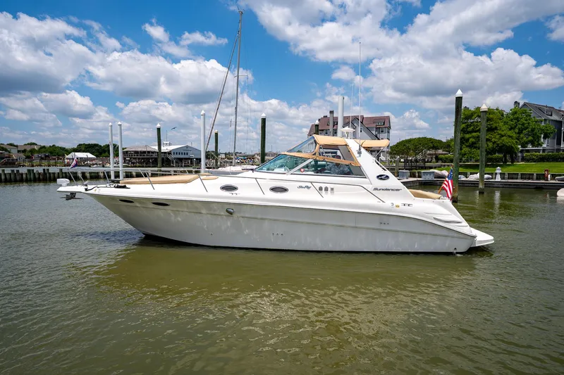 Slide: The Image of 1997 Sea Ray 330 Sundancer yacht docked in a marina under a partly cloudy sky. - 6