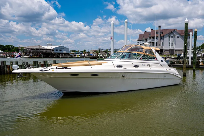 Slide: The Image of 1997 Sea Ray 330 Sundancer yacht docked in a marina under a partly cloudy sky. - 8