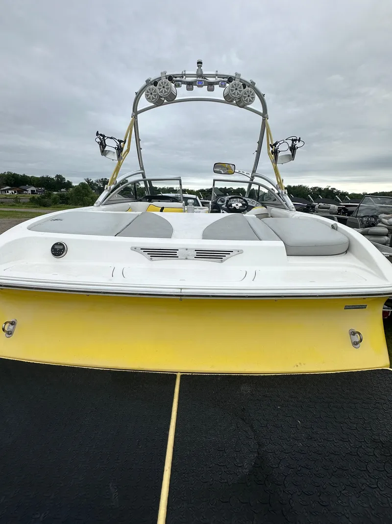 Slide: The Image of 2006 Tigé 22VE/SK boat with yellow and white exterior, rear view. - 19