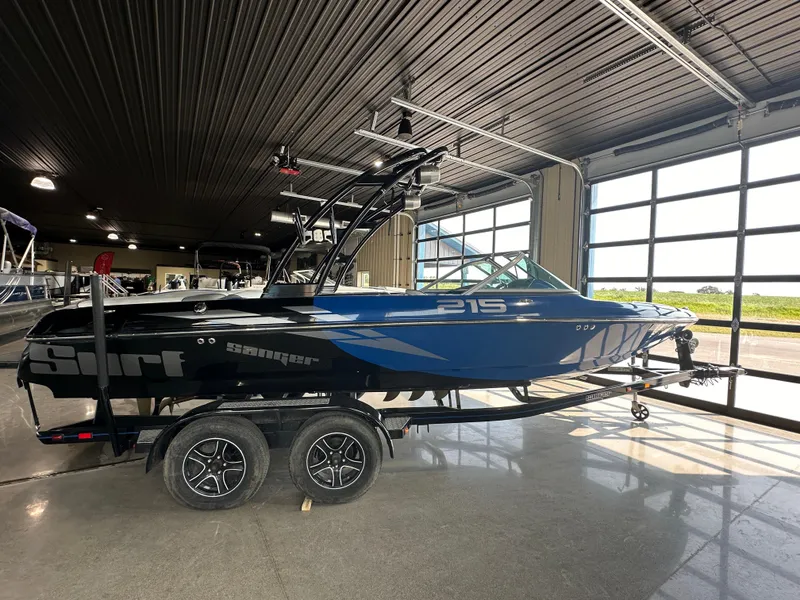 The Image of 2016 Sanger V215 boat in showroom, blue and black, on a trailer. - 0