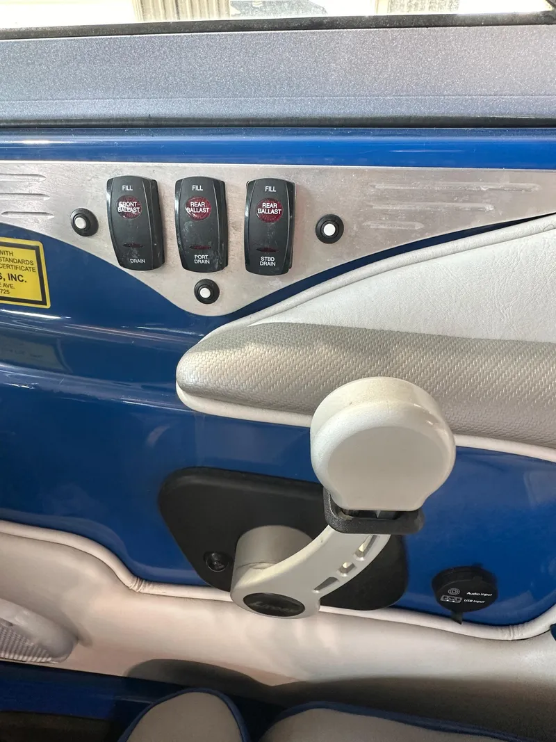 Slide: The Image of Control panel and throttle of a 2016 Sanger V215 boat. - 13