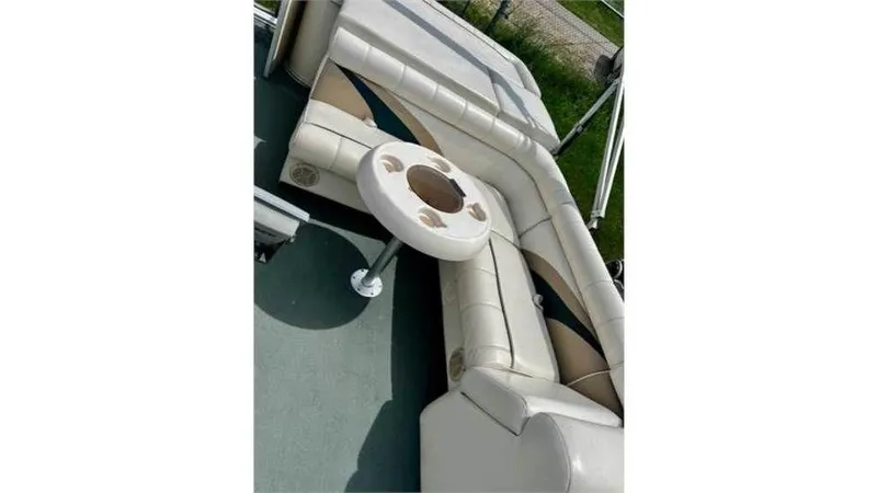 Slide: The Image of 2004 Godfrey Particraft 220SC #19450 boat interior with cushioned seating and table. - 7