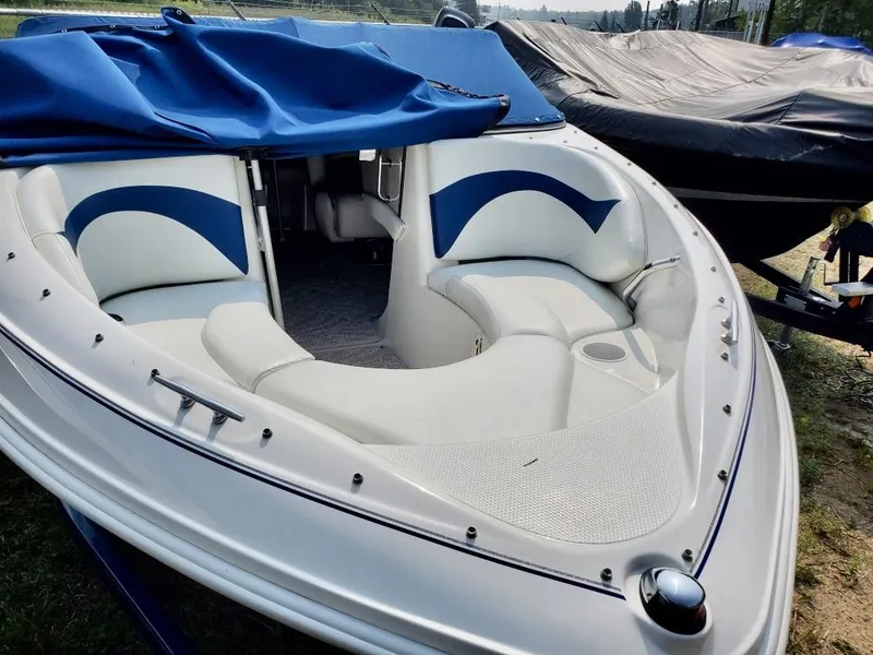 Slide: The Image of 2008 Larson 180 Sport boat with blue and white interior, docked and covered. - 11