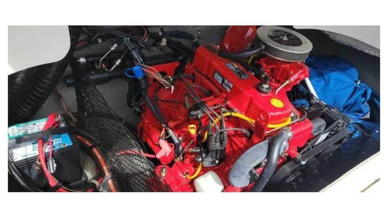Slide: The Image of 2008 Larson 180 Sport boat engine compartment with red engine and battery. - 5