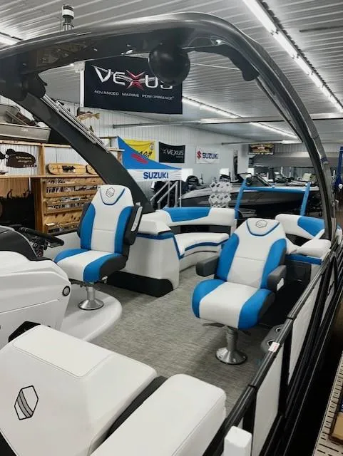 Slide: The Image of 2023 South Bay 523RS ARCH3.0 pontoon boat with blue and white seating in showroom. - 11