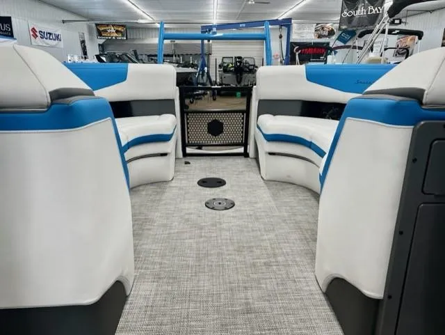 Slide: The Image of Interior of 2023 South Bay 523RS ARCH3.0 pontoon boat with white and blue seating. - 5