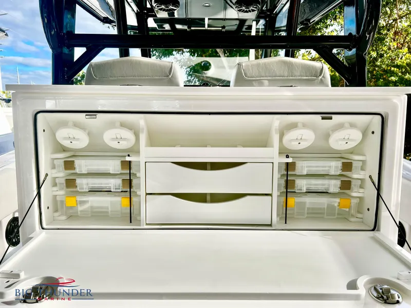 Slide: The Image of 2023 Fountain 38 TE boat storage compartment with organized tackle boxes and drawers. - 15