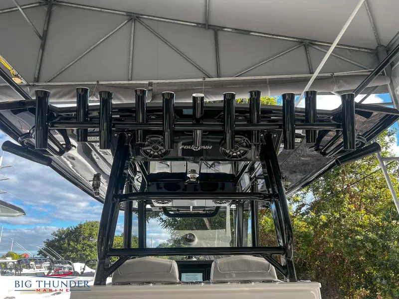 Slide: The Image of 2023 Fountain 38 TE boat under canopy with rod holders and Big Thunder Marine logo. - 18