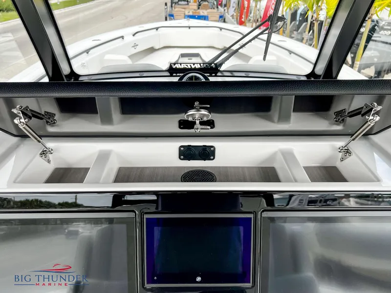 Slide: The Image of 2023 Fountain 38 TE boat dashboard with open storage compartments and touchscreen display. - 33