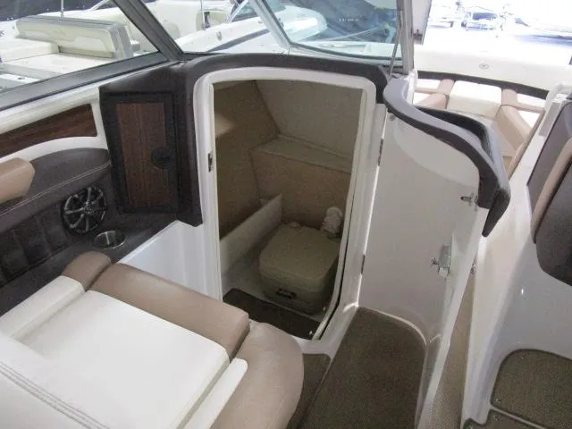 Slide: The Image of 2014 Cobalt 26 SD boat interior with seating and compact restroom. - 16