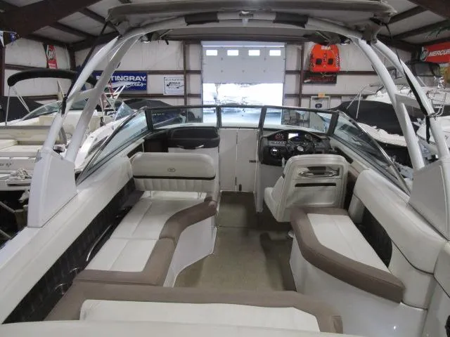 Slide: The Image of 2014 Cobalt 26 SD boat interior with seating and steering wheel in a showroom. - 18