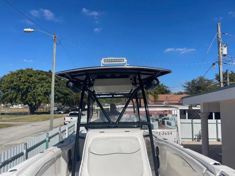 Slide: The Image of 2006 Wellcraft 310 CC boat with T-top and seating, parked outdoors. - 24