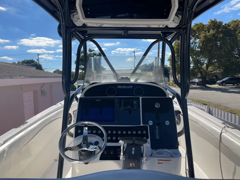 Slide: The Image of 2006 Wellcraft 310 CC boat cockpit with steering wheel and control panel. - 46