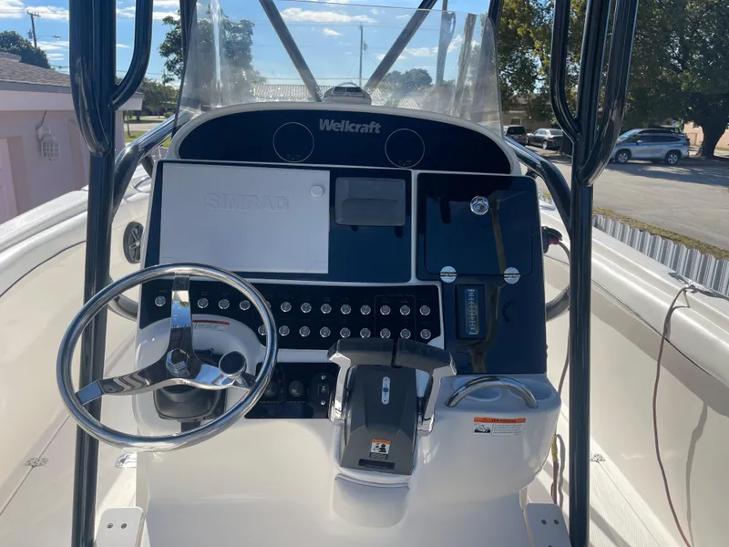 Slide: The Image of 2006 Wellcraft 310 CC boat dashboard with steering wheel and control panel. - 49