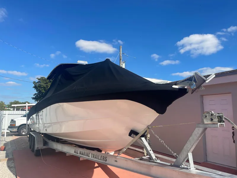 Slide: The Image of 2006 Wellcraft 310 CC boat on trailer with black cover under blue sky. - 7