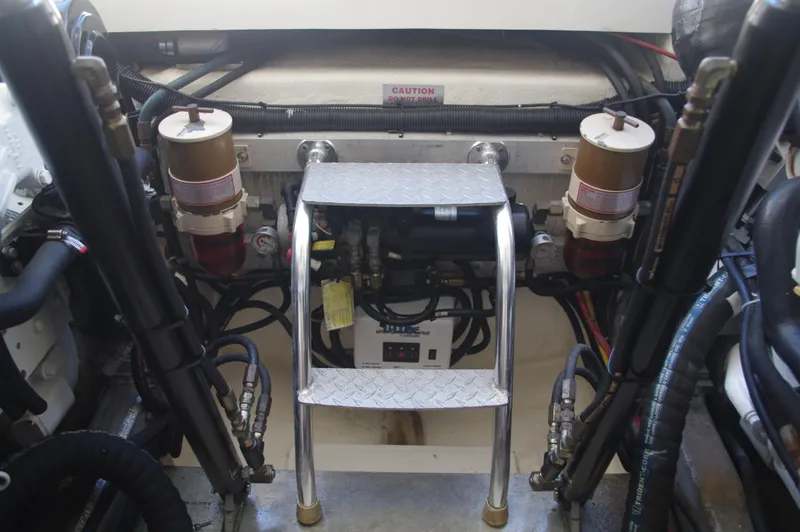 Slide: The Image of Engine room of a 2000 Cabo 35 Express boat with fuel filters and ladder. - 24