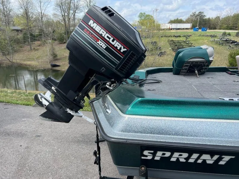 Slide: The Image of 1999 Sprint 286 Pro boat with Mercury XRi outboard motor near a lake. - 5
