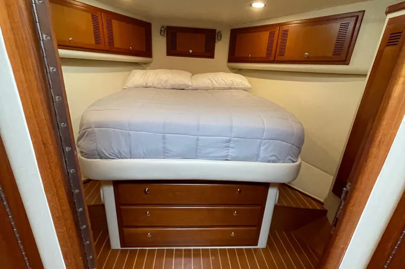 Slide: The Image of Cozy cabin interior of 2003 Cabo Express with wooden cabinets and a comfortable bed. - 3