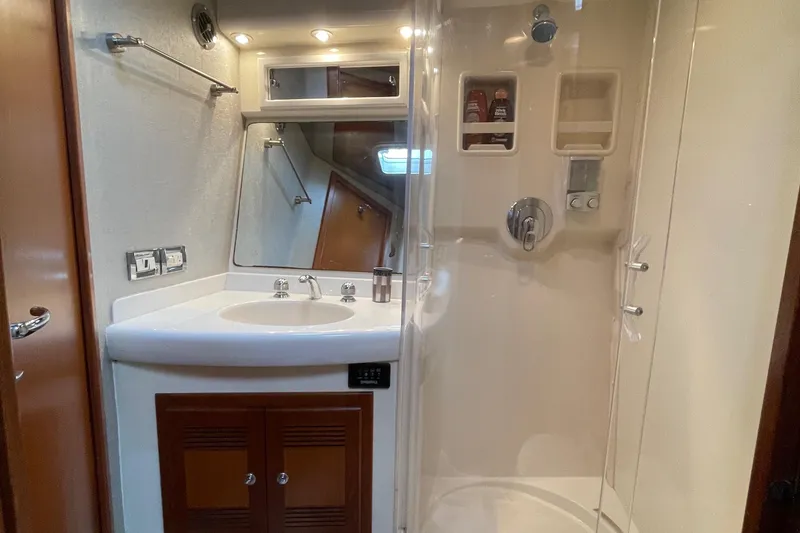 Slide: The Image of 2003 Cabo Express bathroom with shower, sink, and mirror in compact marine design. - 5