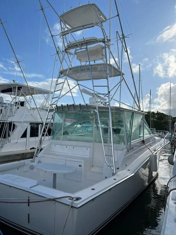 Slide: The Image of 2003 Cabo Express boat docked at marina under clear blue sky. - 7