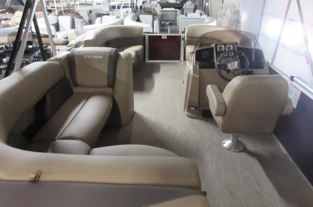Slide: The Image of 2023 Sylvan 8520 Mirage Cruise interior with beige seating and steering console. - 7