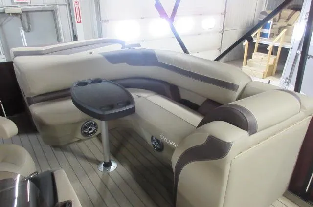 Slide: The Image of 2022 Sylvan L-1 Cruise boat interior with beige seating and a small table. - 3