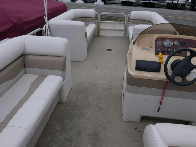 Slide: The Image of Interior of a 2003 Sylvan 822 Mirage Cruise pontoon boat with white and beige seating. - 9
