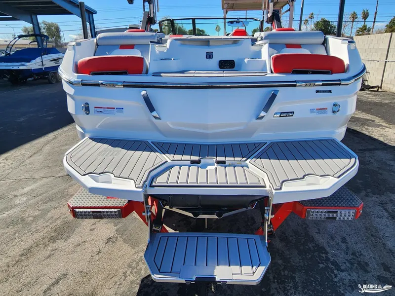 Slide: The Image of 2023 MasterCraft X26 boat rear view with swim platform and red seating. - 10