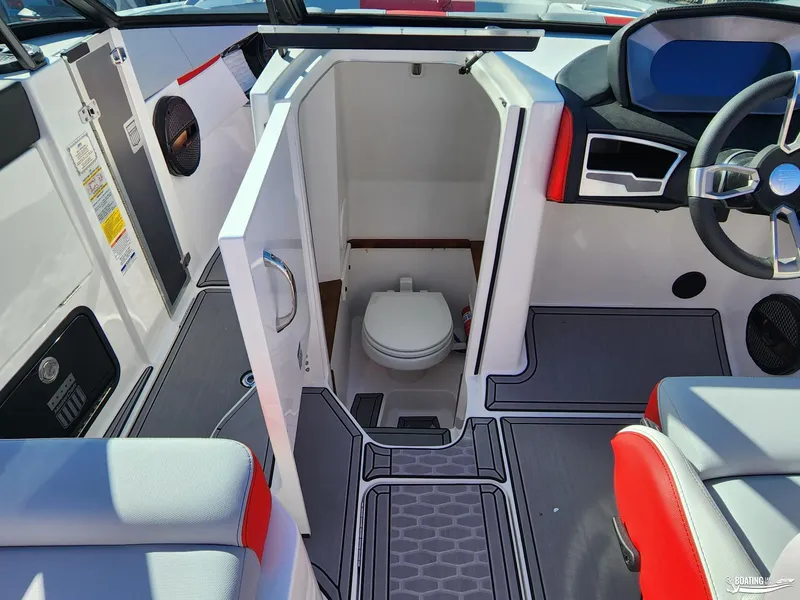 Slide: The Image of 2023 MasterCraft X26 boat interior with open bathroom door and modern seating. - 15