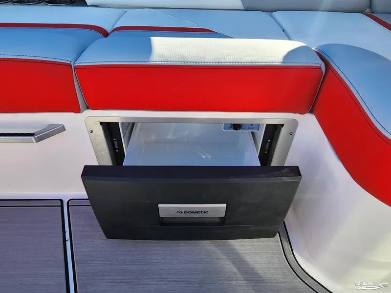 Slide: The Image of 2023 MasterCraft X26 boat with open Dometic drawer fridge under red and white seating. - 21