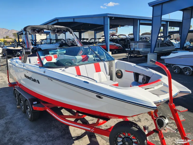 Slide: The Image of 2023 MasterCraft X26 boat on a red trailer, displayed outdoors. - 6