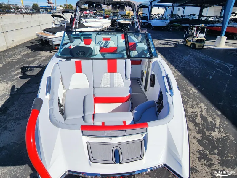 Slide: The Image of 2023 MasterCraft X26 boat with red and gray interior, parked in a marina. - 7
