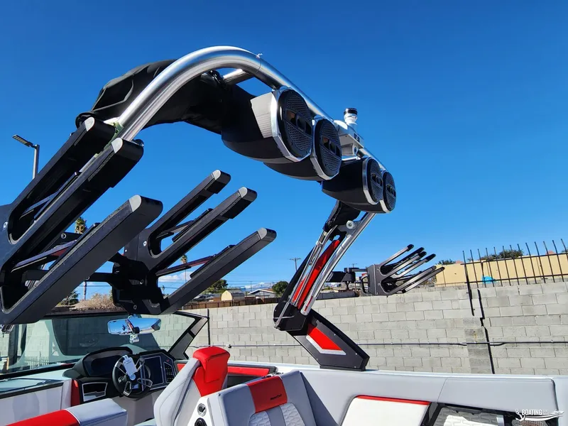 Slide: The Image of 2023 MasterCraft X26 boat with advanced wakeboard tower and speakers under clear blue sky. - 9