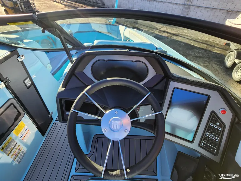 Slide: The Image of 2023 MasterCraft XStar S boat dashboard with steering wheel and digital controls. - 10