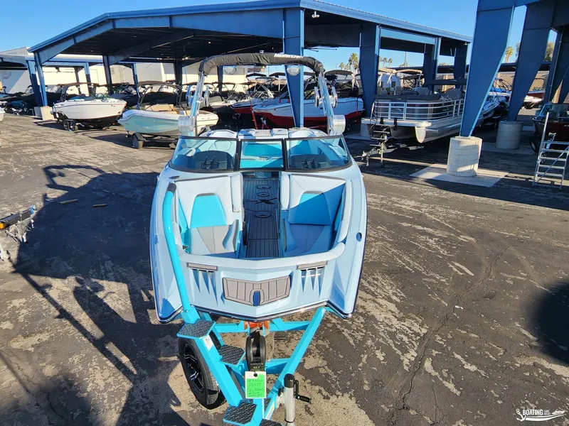 Slide: The Image of 2023 MasterCraft XStar S boat in a marina, vibrant blue and gray design. - 3