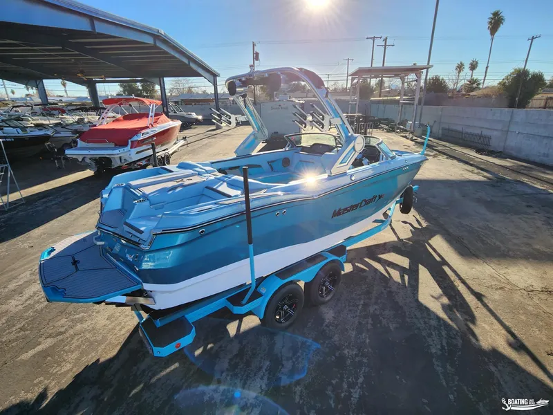 Slide: The Image of 2023 MasterCraft XStar S boat in a sunny marina setting. - 5