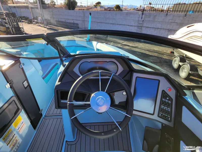 Slide: The Image of 2023 MasterCraft XStar S boat cockpit with modern steering wheel and digital controls. - 8