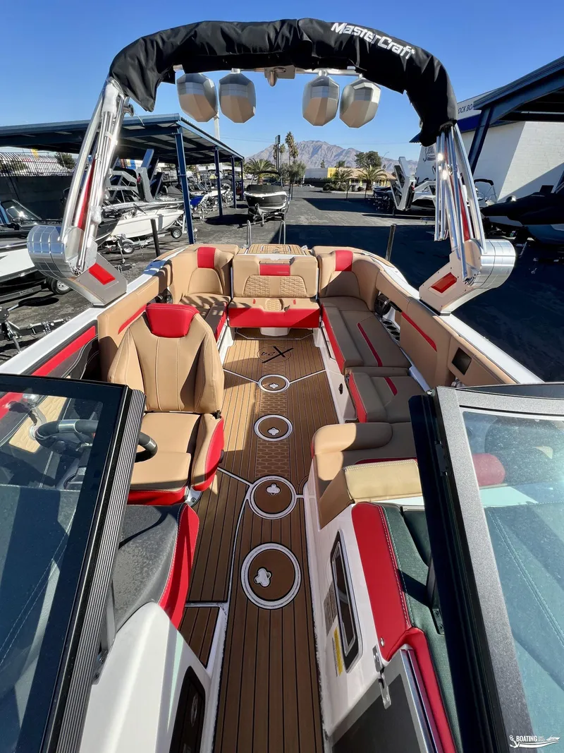 Slide: The Image of 2023 MasterCraft X24 boat interior with tan and red seating, sleek design, and advanced features. - 6